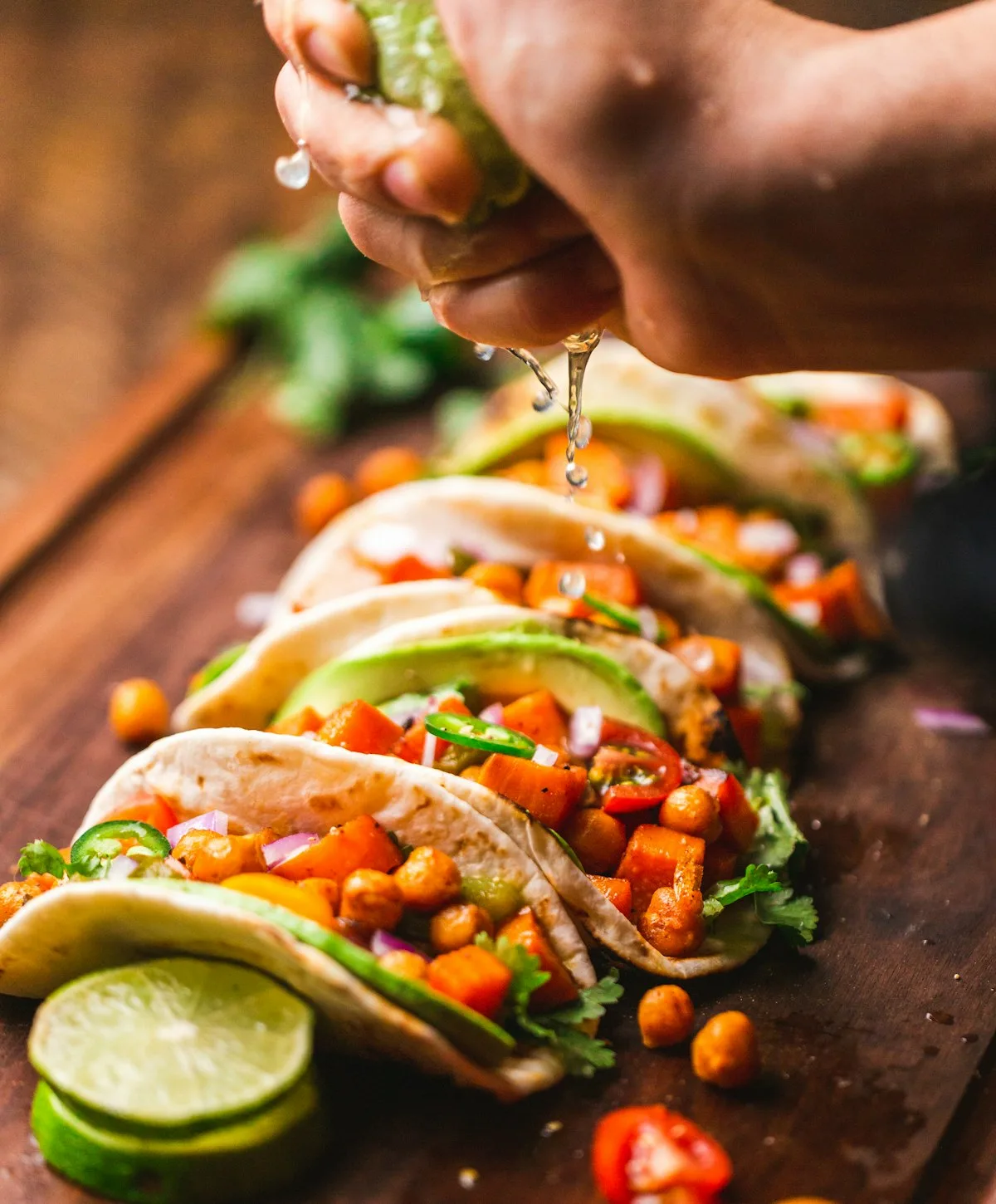 Crispy golden quesabirria tacos loaded with shredded beef and melted cheese served with a bowl of rich red birria consomé, lime, and cilantro