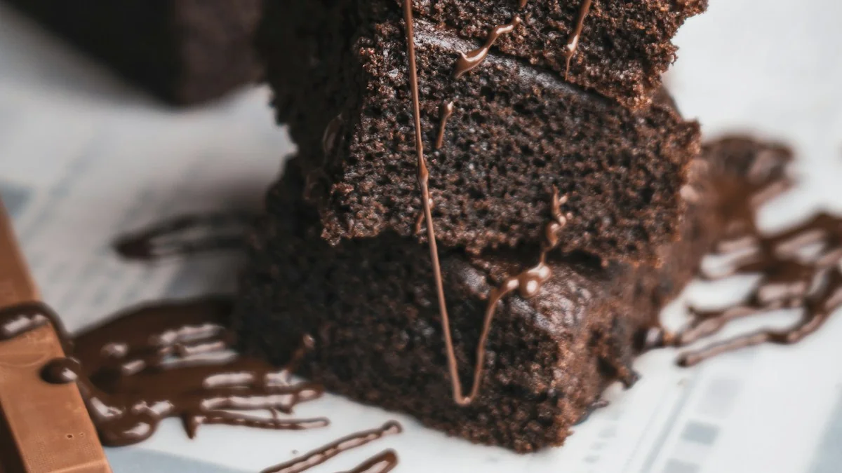 A stack of freshly sliced ultra-fudgy homemade chocolate brownies with shiny crinkled tops and gooey chocolate centers.