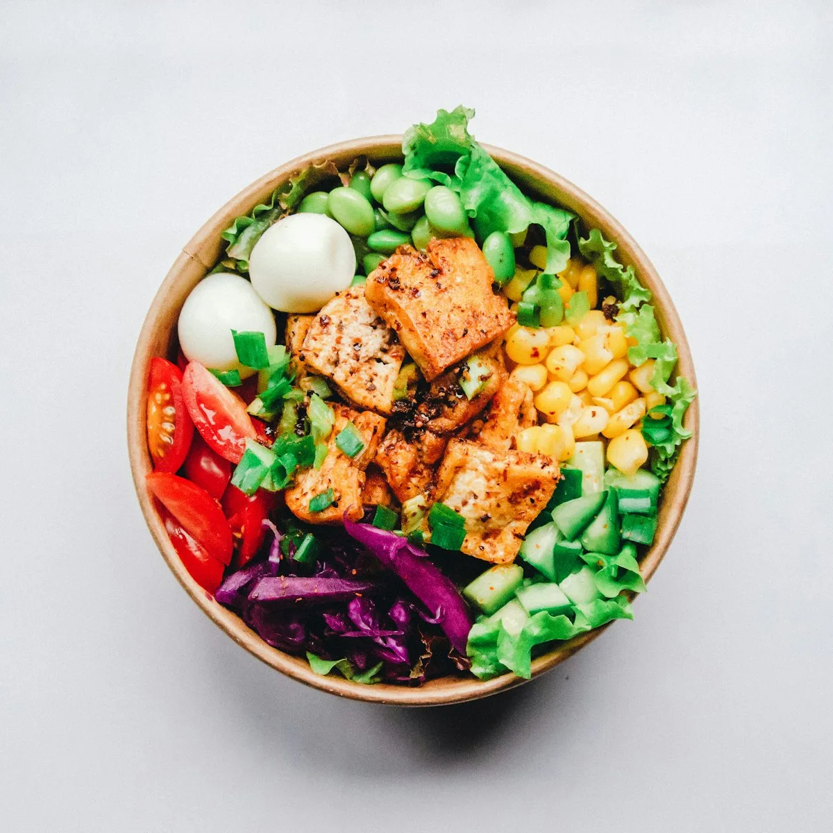 High-protein air fryer honey Dijon chicken bites served with roasted broccoli, sweet peppers, and fluffy quinoa in a ceramic bowl