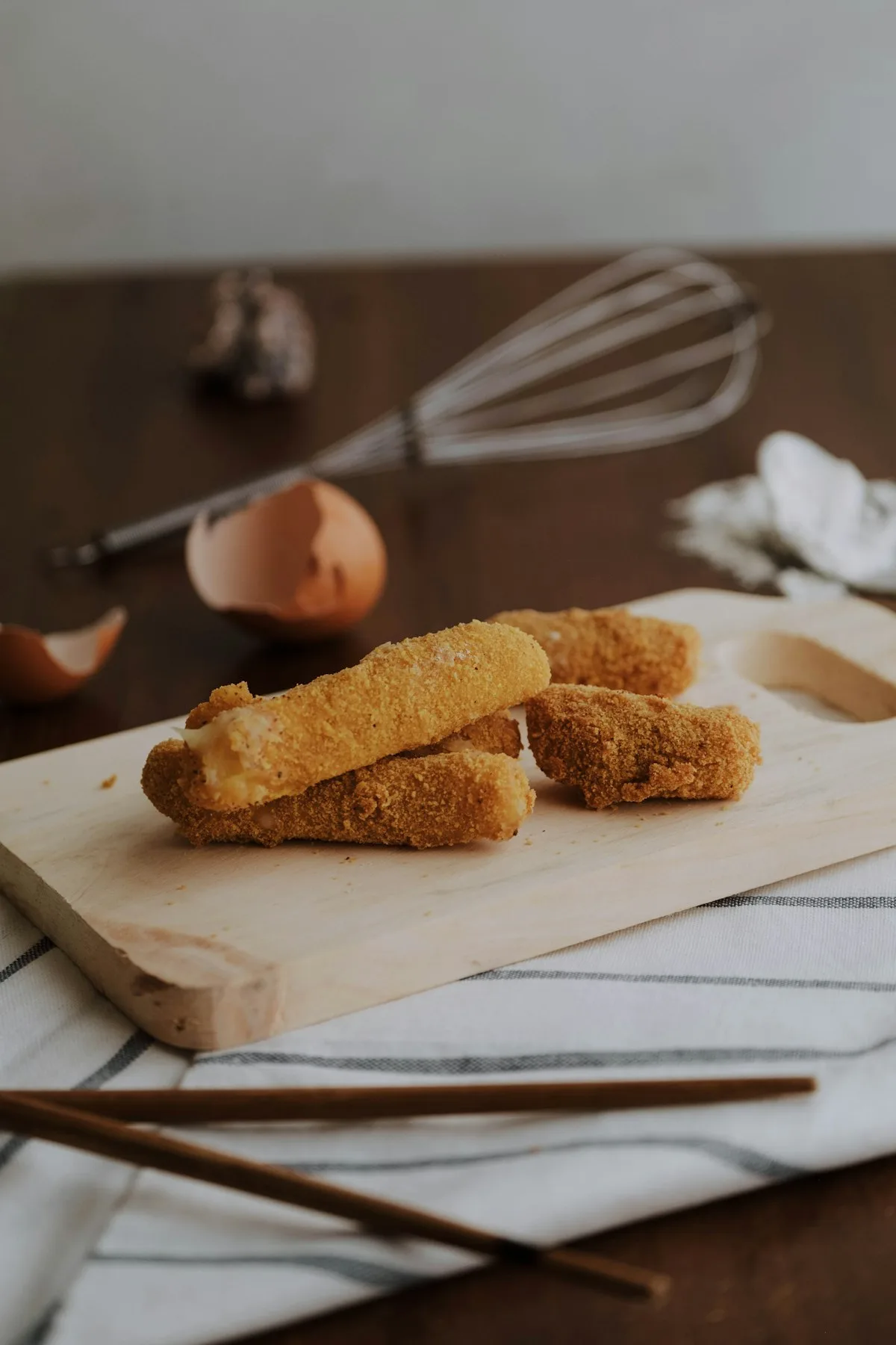 Golden crispy air fryer mozzarella stick pulled apart showing a long, stretchy melted cheese pull with warm marinara dipping sauce