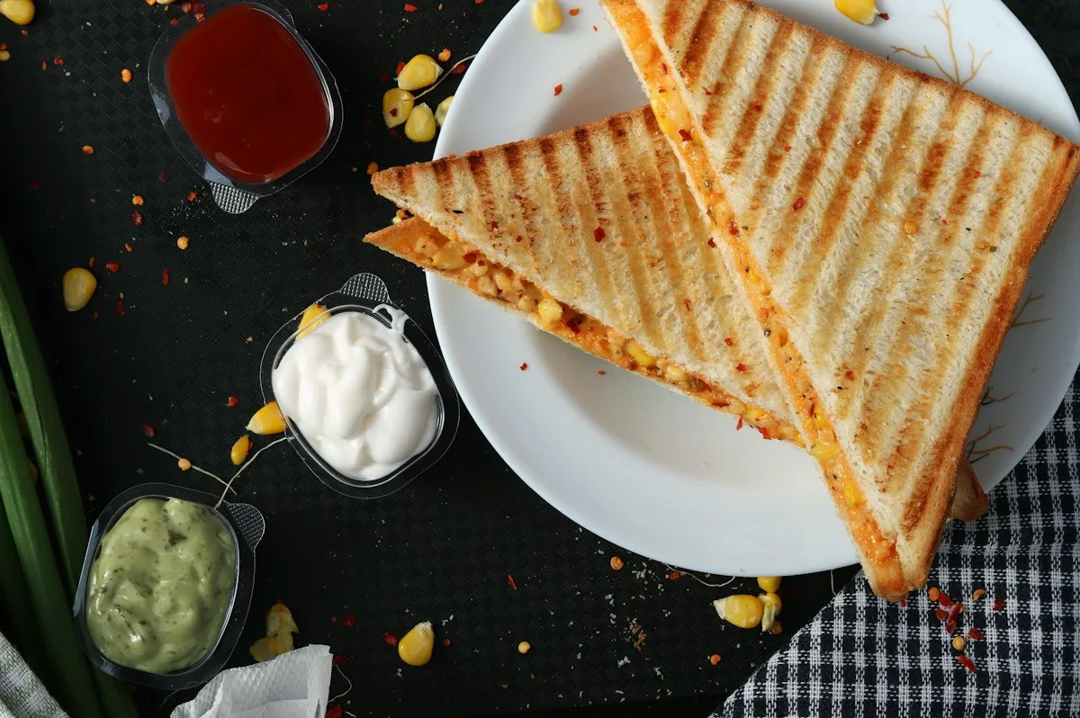 Golden crispy cheese toastie cut in half with gooey melted cheddar stretching between thick slices of sourdough bread under the grill
