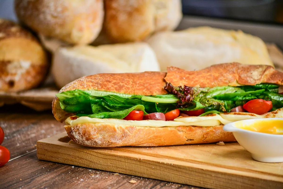 Crusty toasted Italian hoagie roll overflowing with viral chopped deli meats, melted provolone, and creamy tangy Italian grinder salad
